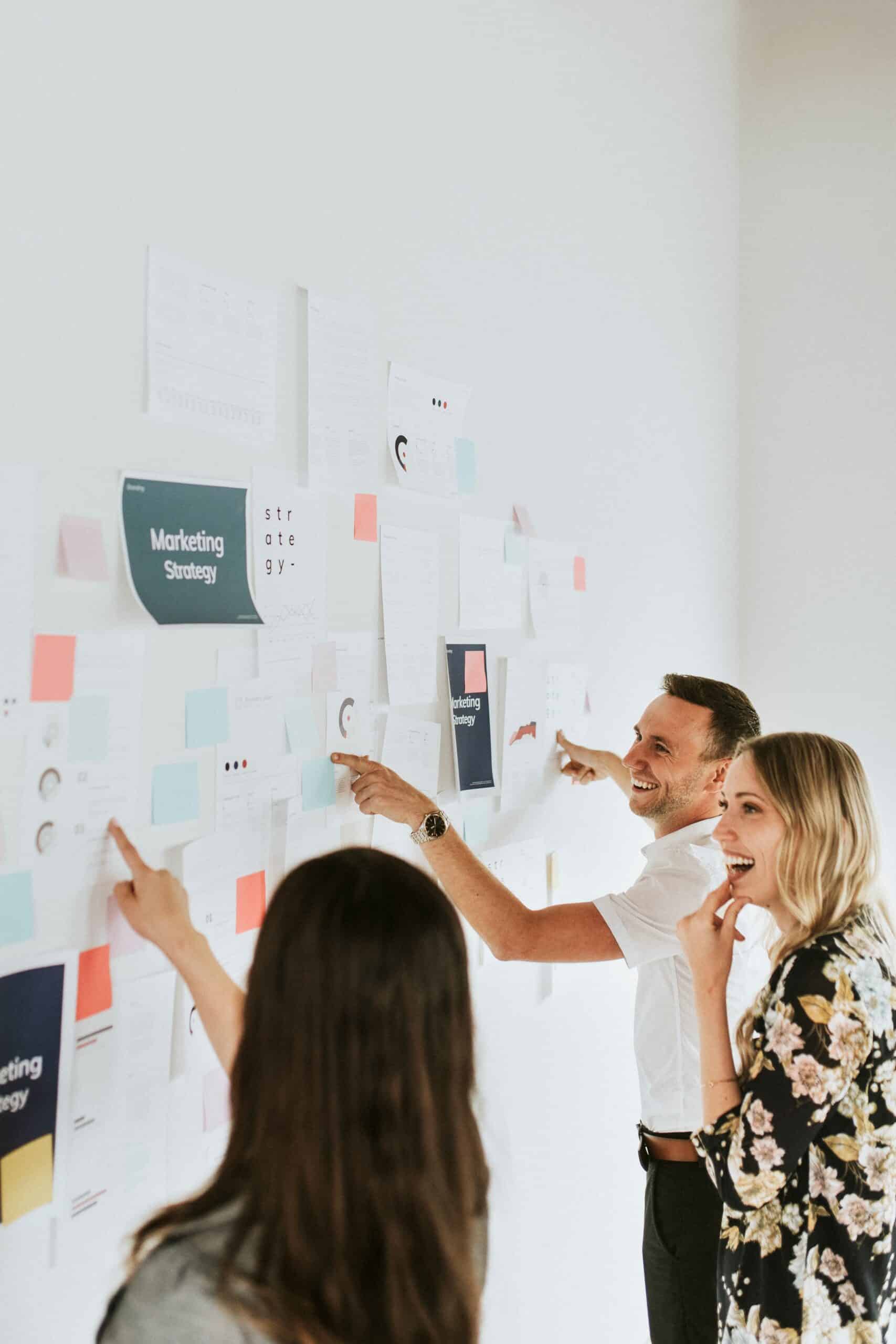 Marketing team building a brand positioning strategy on a whiteboard with competitive analysis