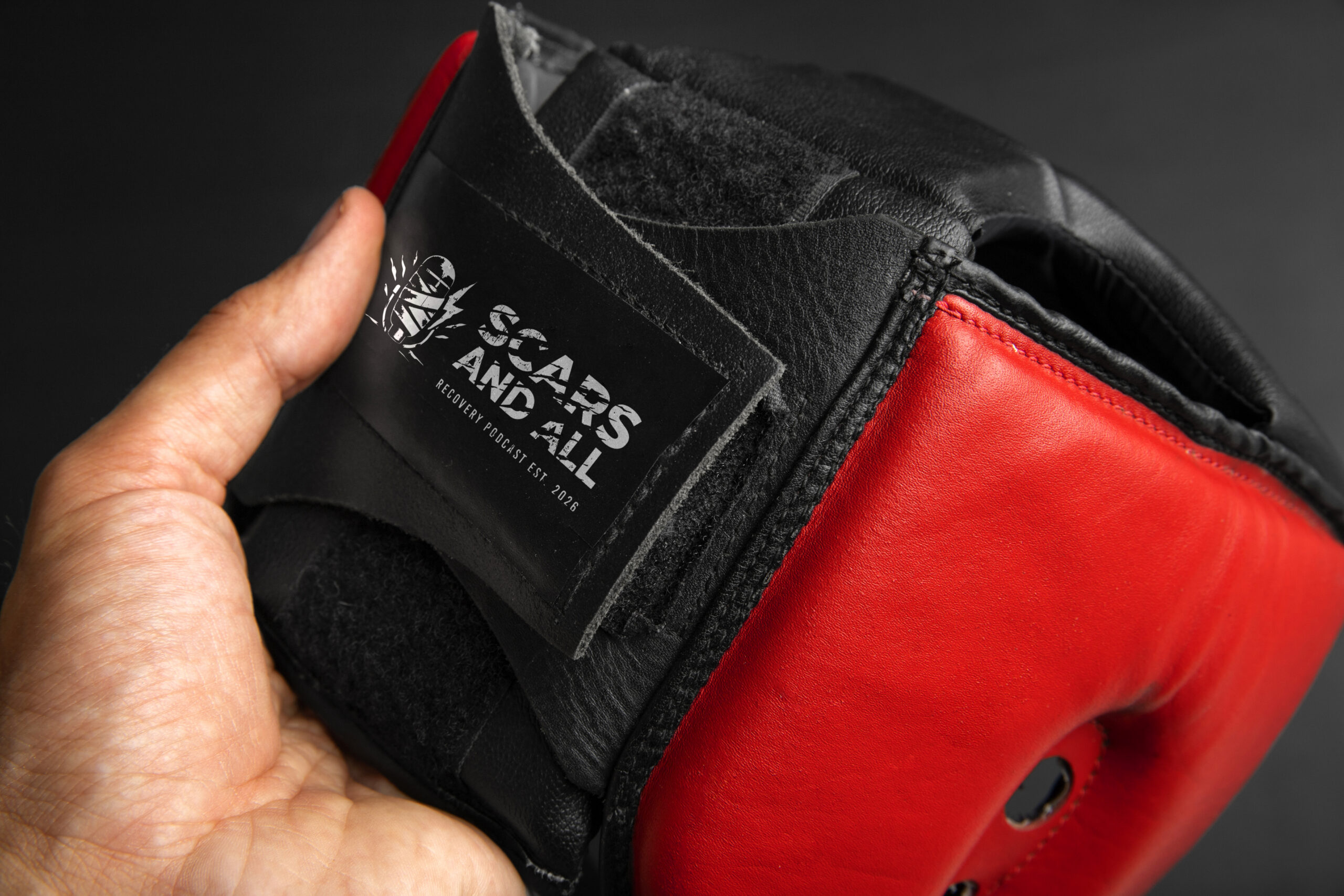 The Scars and All sparring headgear: black and red leather, embossed mark