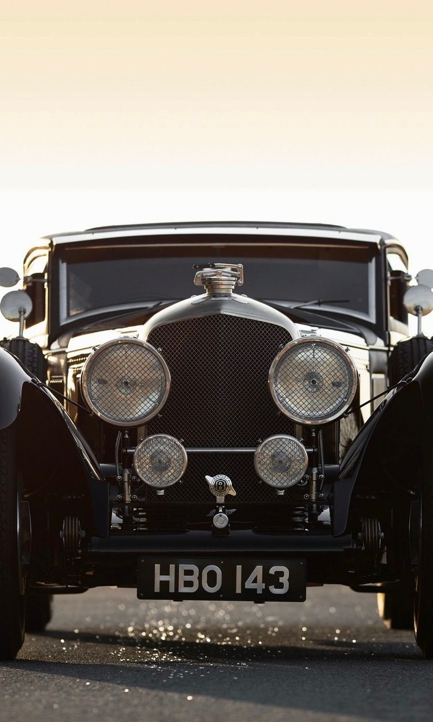 Bentley Speed Six head-on and backlit: four lamps and the mesh grille