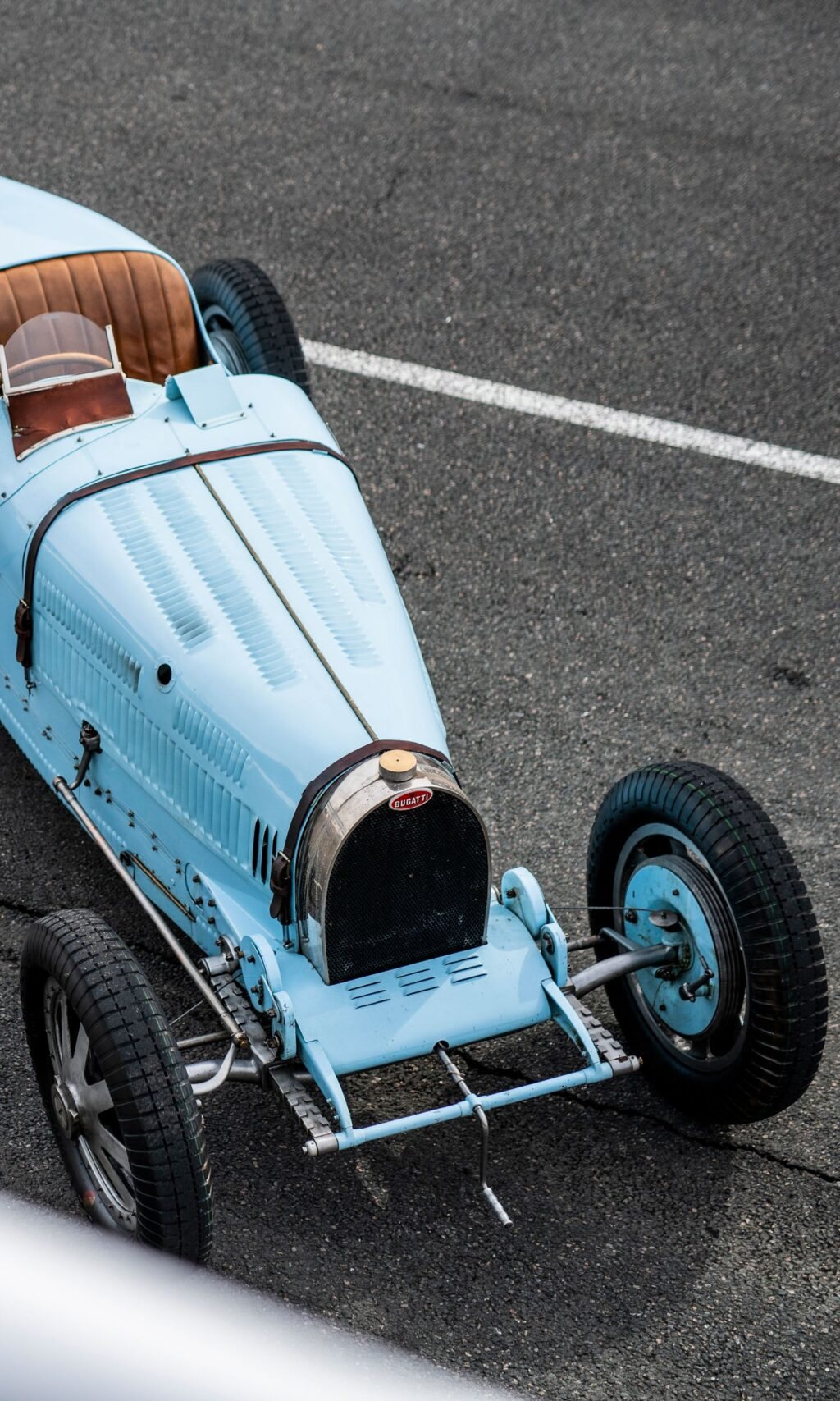 Pale blue Bugatti Type 35 seen from above on a track, horseshoe grille forward