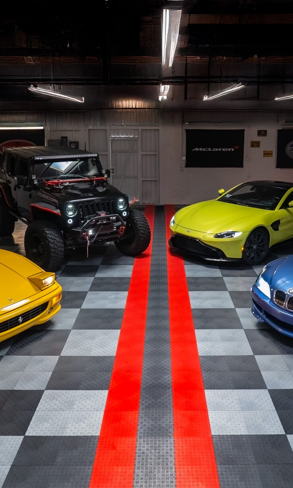 The Studio Motors showroom floor in Burbank: checkered tiles, two red stripes, cars parked on both sides