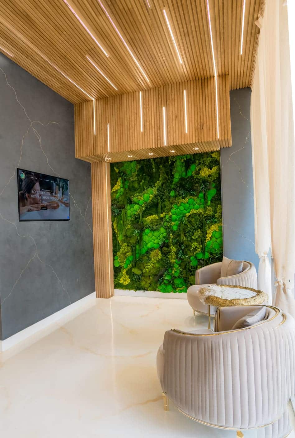 The lobby at Empower Wellness Spa: a moss wall, a slatted wood ceiling and two lounge chairs